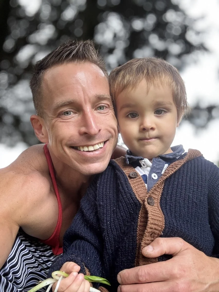 Martin holding his son Oliver outdoors.